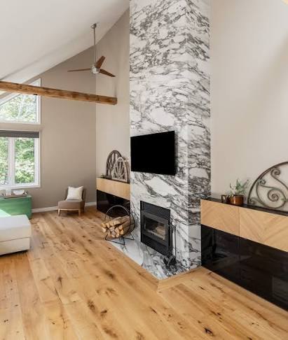 Wide-plank wood flooring beside a stone fireplace, design inspiration